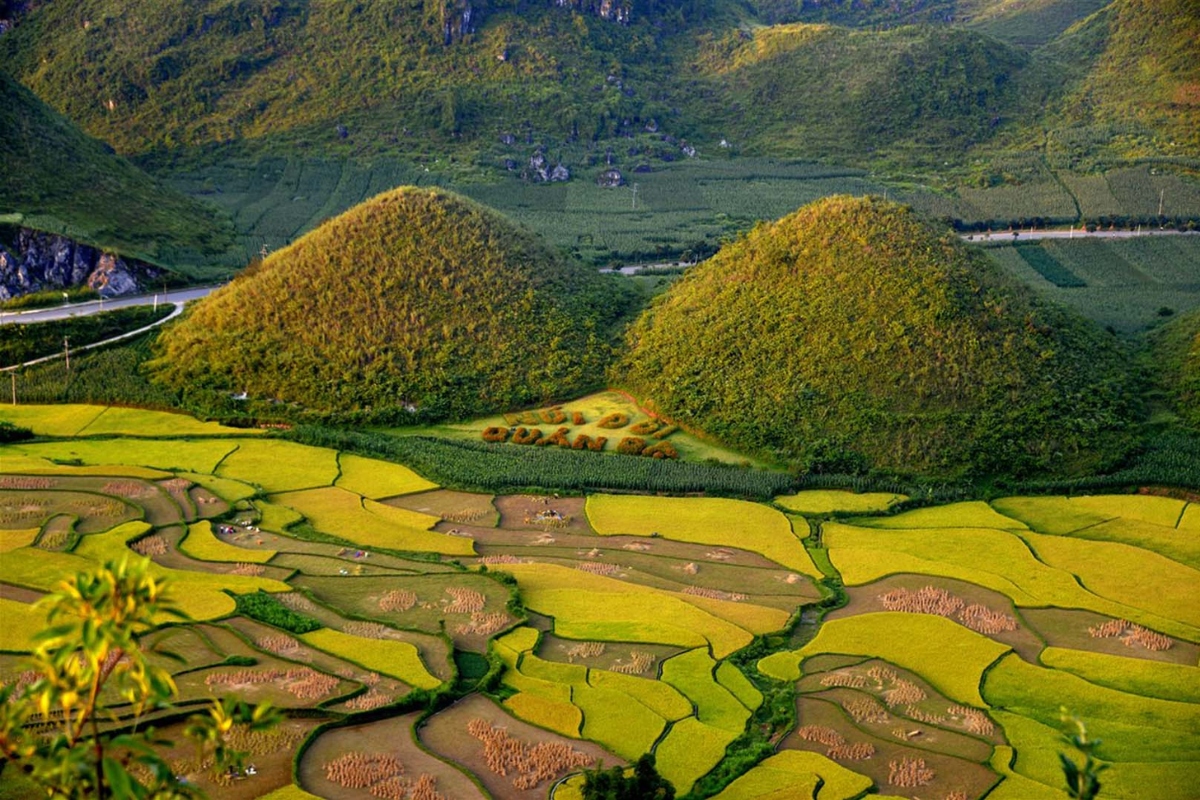 Twin Mountains of Quan Ba at sunrise with misty valleys below